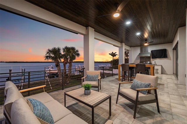 view of patio with an outdoor hangout area, ceiling fan, and a water view