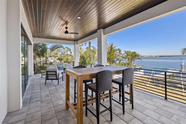 view of patio / terrace featuring outdoor dining space, ceiling fan, and a water view