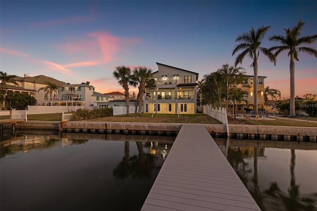 dock area with fence, a water view, a yard, a balcony, and a patio area