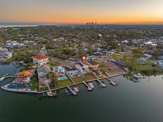 aerial view at dusk featuring a water view