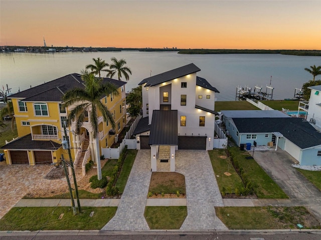 aerial view at dusk featuring a water view