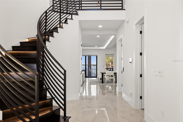 entryway with baseboards, marble finish floor, recessed lighting, and stairway