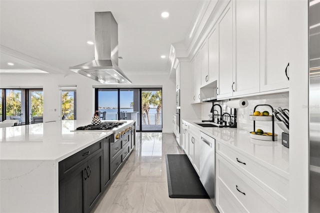 kitchen with white cabinetry, stainless steel appliances, island exhaust hood, a kitchen island, and a sink