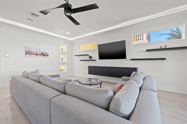 living area featuring baseboards, ceiling fan, visible vents, and a fireplace