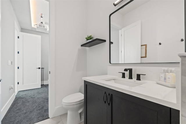bathroom featuring toilet, vanity, and baseboards