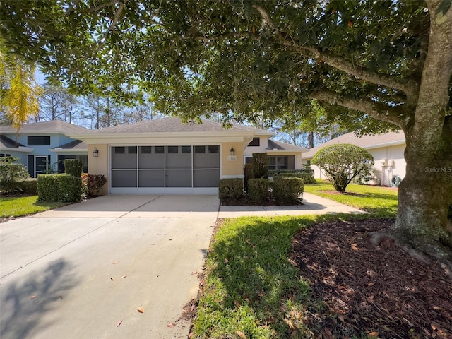 single story home with a front lawn, concrete driveway, an attached garage, and stucco siding