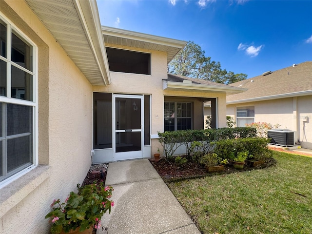 doorway to property featuring a lawn, cooling unit, and stucco siding