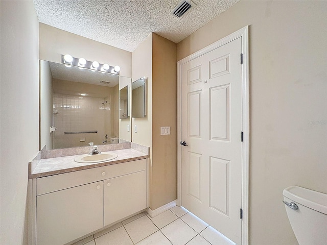 full bathroom with a textured ceiling, toilet, visible vents, tile patterned floors, and walk in shower