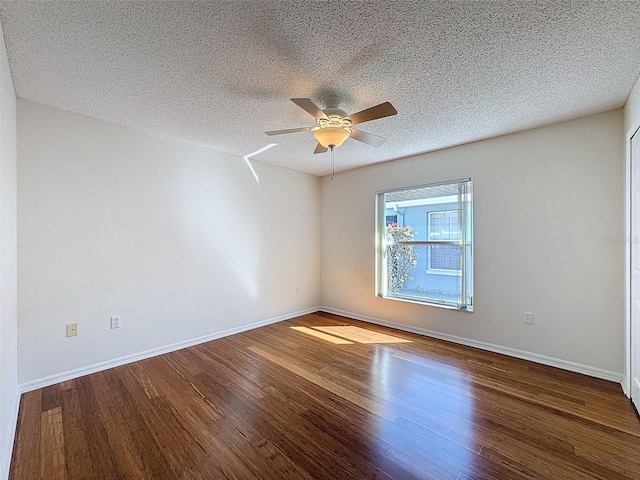 spare room with a ceiling fan, a textured ceiling, baseboards, and wood finished floors