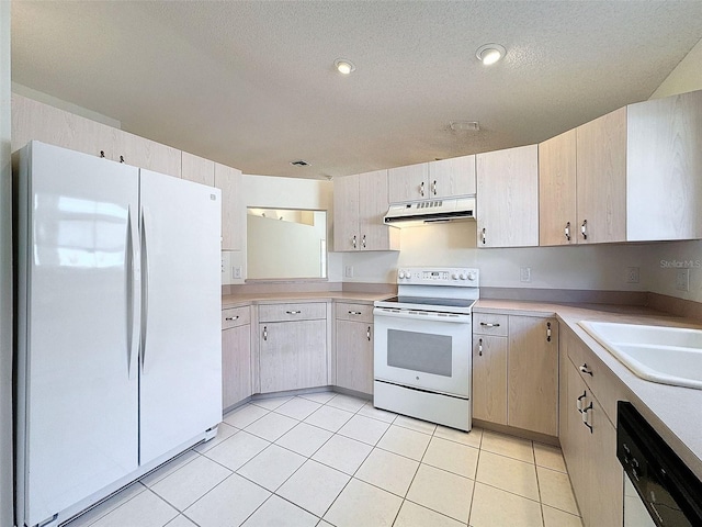 kitchen featuring light tile patterned floors, light countertops, a sink, white appliances, and under cabinet range hood