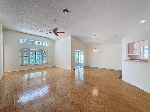 unfurnished living room featuring lofted ceiling, hardwood / wood-style flooring, plenty of natural light, and visible vents