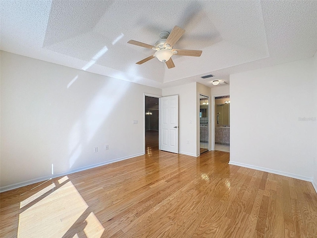 unfurnished bedroom with a textured ceiling, visible vents, and light wood-style floors