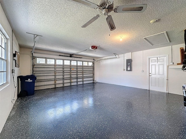 garage with ceiling fan, electric panel, and a garage door opener