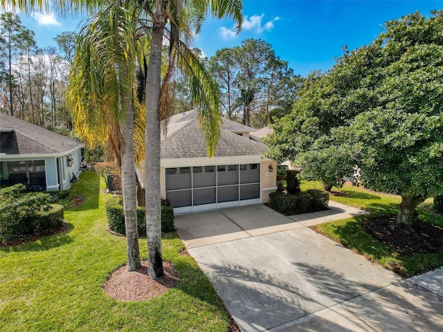 view of front facade with a garage, driveway, a shingled roof, and a front lawn