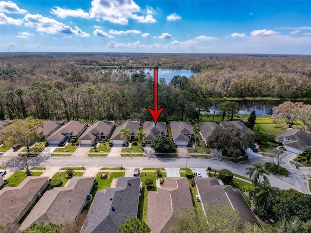 drone / aerial view with a residential view, a water view, and a view of trees