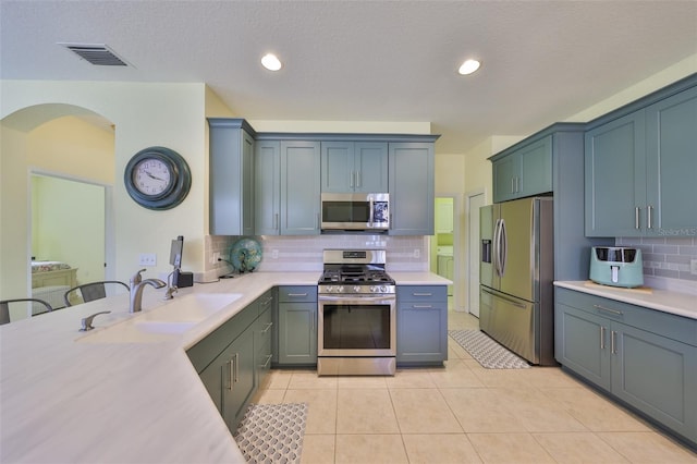 kitchen with light countertops, appliances with stainless steel finishes, a sink, and visible vents