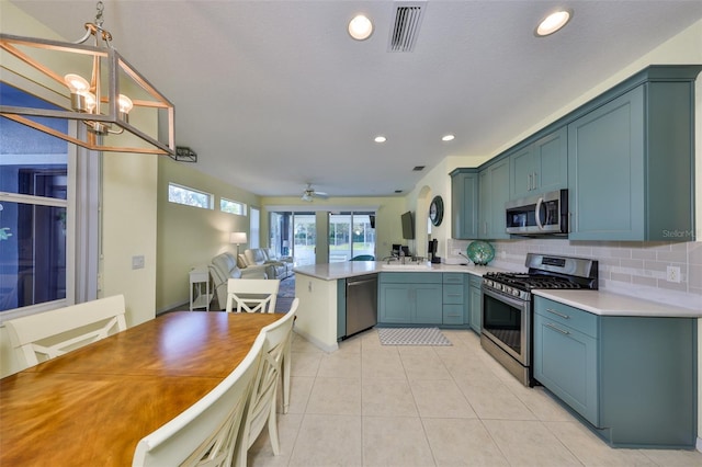 kitchen with a peninsula, visible vents, open floor plan, appliances with stainless steel finishes, and backsplash