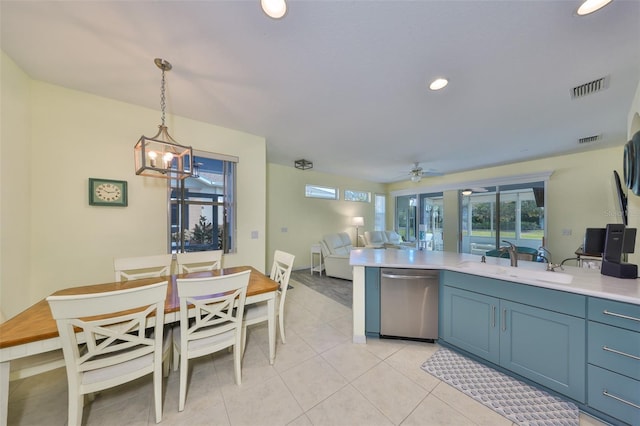 kitchen with light tile patterned floors, a peninsula, light countertops, stainless steel dishwasher, and a sink