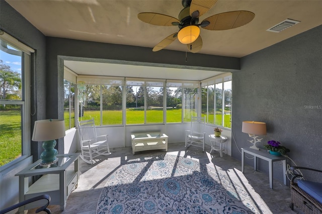 sunroom with ceiling fan, visible vents, and a healthy amount of sunlight