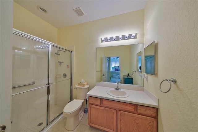 bathroom featuring a textured wall, toilet, vanity, visible vents, and a stall shower