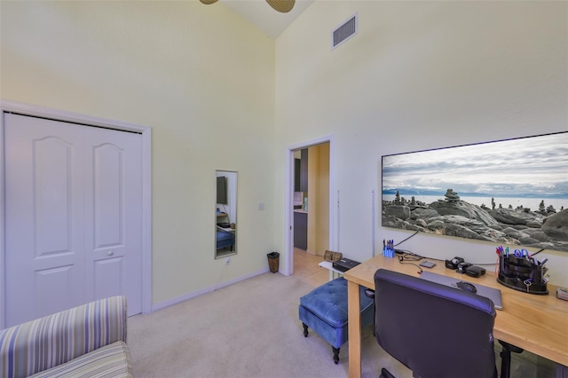 home office with visible vents, high vaulted ceiling, a ceiling fan, and light colored carpet