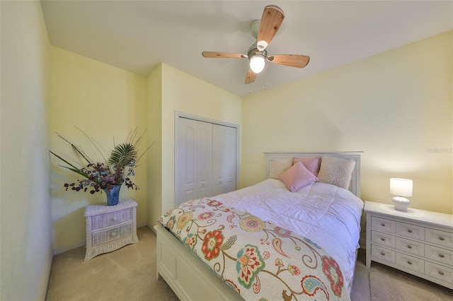 bedroom with a closet, light colored carpet, and ceiling fan