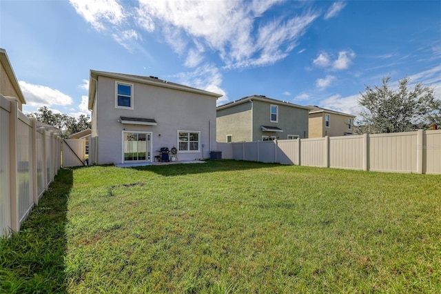 back of house with a lawn, cooling unit, a fenced backyard, and stucco siding