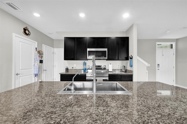 kitchen featuring recessed lighting, dark cabinets, a sink, visible vents, and appliances with stainless steel finishes