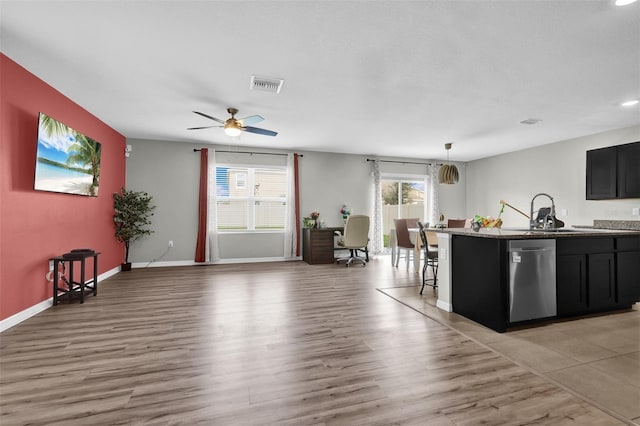 kitchen featuring visible vents, a sink, light wood-style flooring, and dishwasher