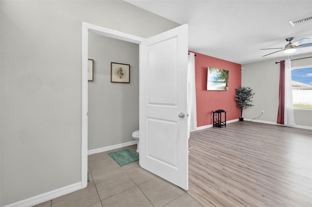 interior space featuring light wood finished floors, baseboards, and visible vents