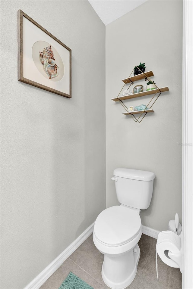 bathroom with baseboards and toilet