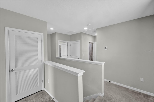 corridor featuring carpet floors, recessed lighting, baseboards, and an upstairs landing