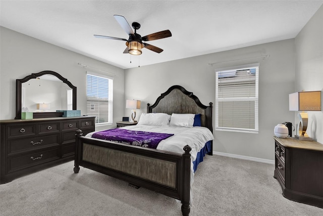 bedroom with a ceiling fan, light colored carpet, and baseboards