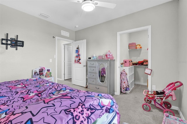 carpeted bedroom featuring visible vents, baseboards, a ceiling fan, a walk in closet, and a closet