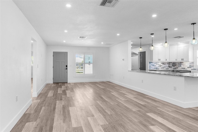 unfurnished living room featuring light wood finished floors, baseboards, visible vents, and recessed lighting