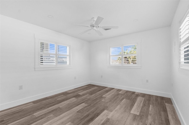 spare room featuring a ceiling fan, baseboards, and wood finished floors