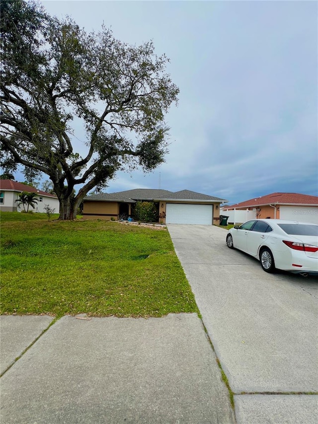 ranch-style house featuring driveway, a garage, and a front yard