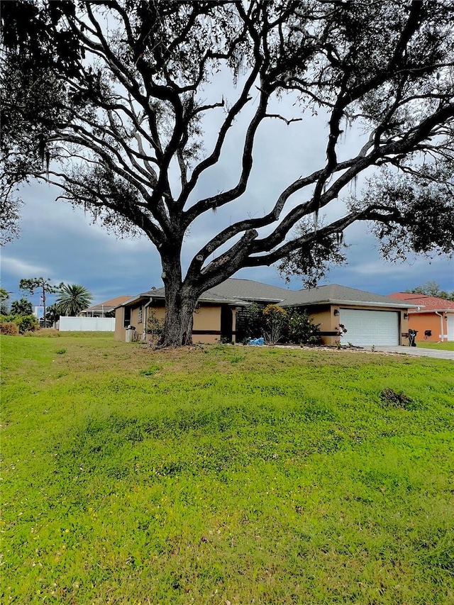 view of front of home featuring a garage, driveway, and a front yard