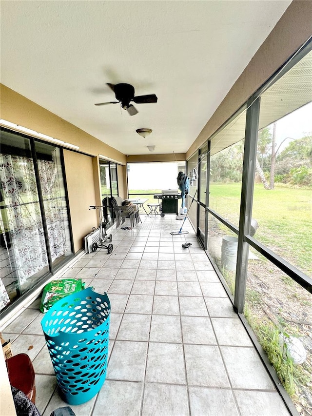 unfurnished sunroom featuring ceiling fan