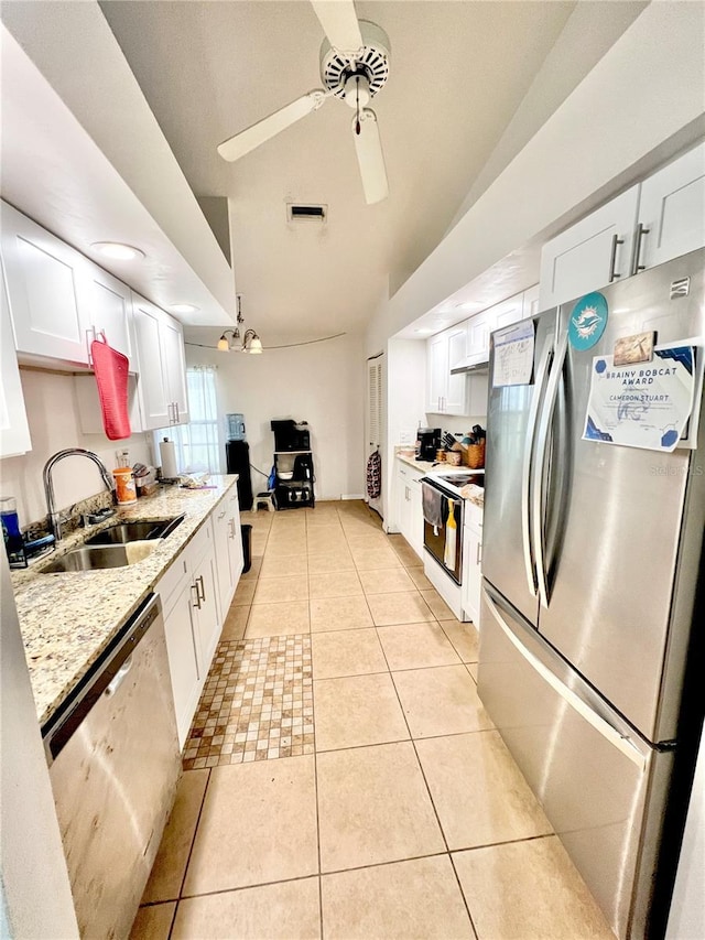 kitchen with light tile patterned floors, stainless steel appliances, a sink, visible vents, and white cabinets