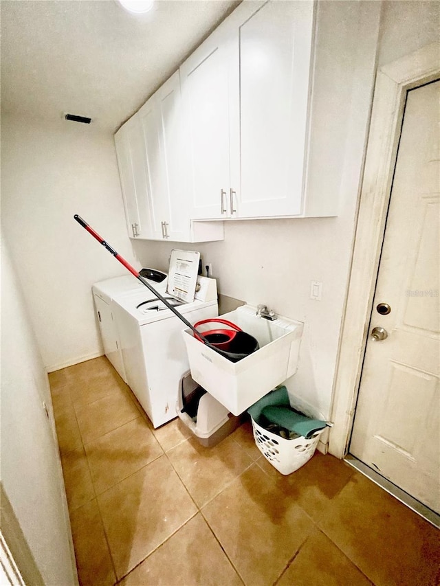 washroom with a sink, cabinet space, washer and dryer, and light tile patterned flooring