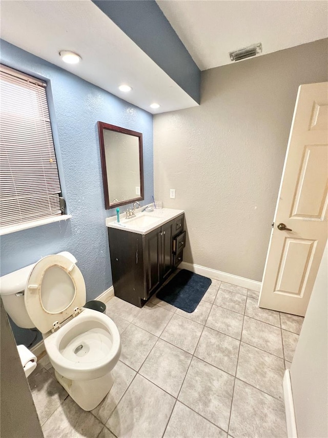 bathroom with tile patterned flooring, toilet, a sink, visible vents, and baseboards