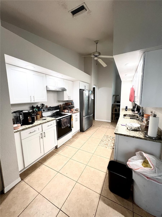 kitchen featuring visible vents, electric range oven, freestanding refrigerator, under cabinet range hood, and a sink