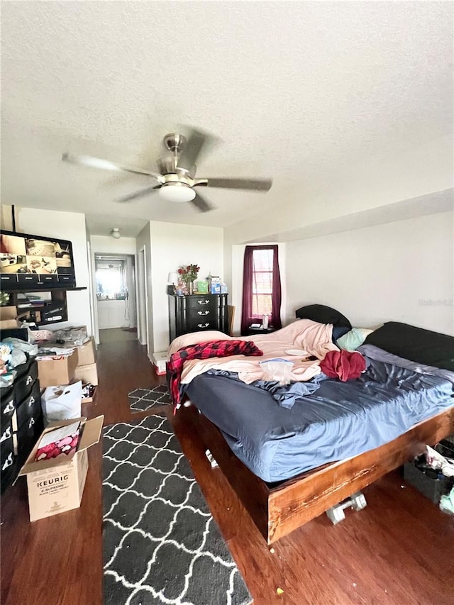 bedroom featuring ceiling fan, a textured ceiling, and wood finished floors