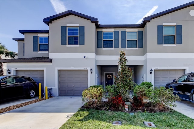 multi unit property featuring driveway, an attached garage, and stucco siding