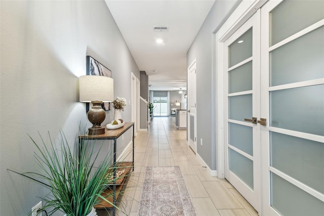 hallway with visible vents and baseboards