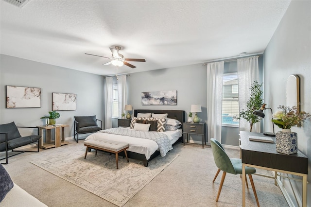 bedroom with light carpet, visible vents, a textured ceiling, and ceiling fan