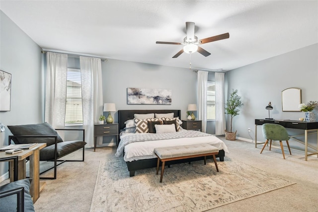 bedroom featuring baseboards, light carpet, and ceiling fan