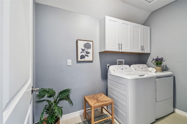 laundry area with cabinet space, separate washer and dryer, baseboards, and light wood-type flooring