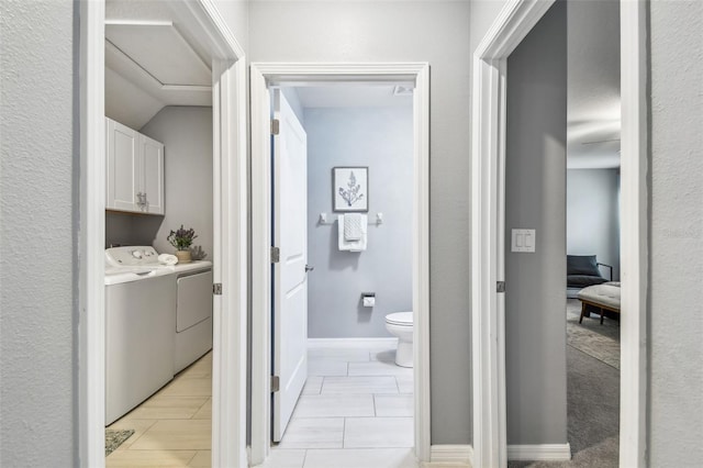 laundry area with cabinet space, washer and dryer, and baseboards